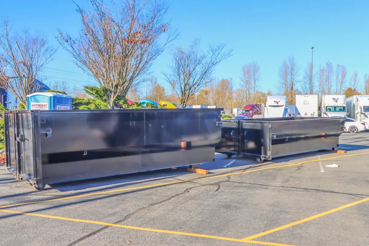 Professional dumpster rental service with roll-off container on residential driveway in Port Jefferson